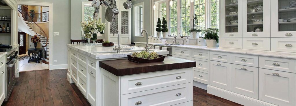 A kitchen with white colored cabinets.