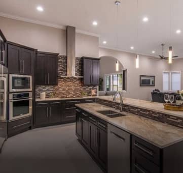 A kitchen with dark colored cabinets.