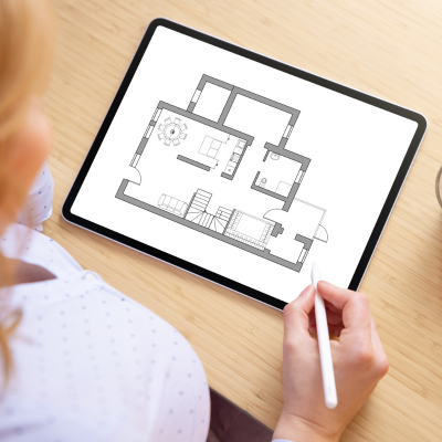 A lady looking at a tablet with a house blueprint on the screen.