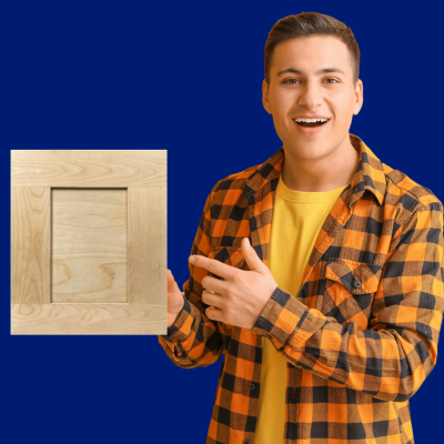 A man smiling and holding a cabinet door sample in one hand, and pointing at it with his other hand.